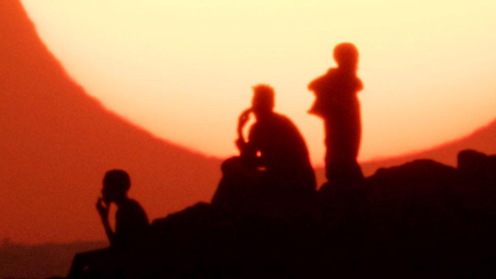 Ethiopian refugees who fled the Ethiopia's Tigray conflict watch the sunset on a hill at the Um Raquba refugee camp in Sudan's eastern Gedaref state on December 12, 2020.