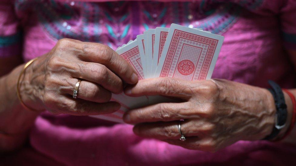 Bridge player Rita Choksi, 79, holds cards during an interview with AFP at her residence in New Delhi