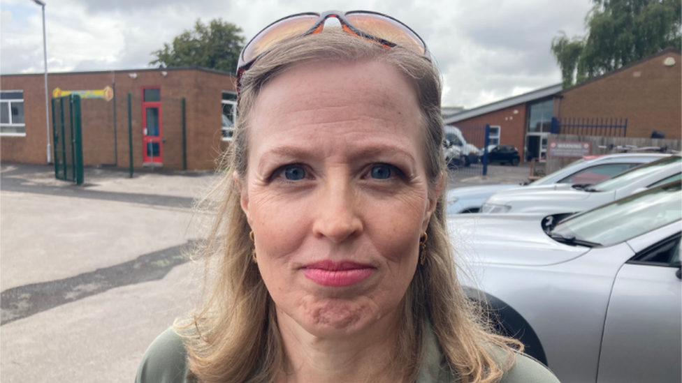 A woman standing in a car park