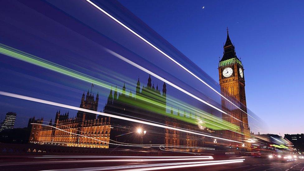 A bus travels along Westminster Bridge past the Houses of Parliament