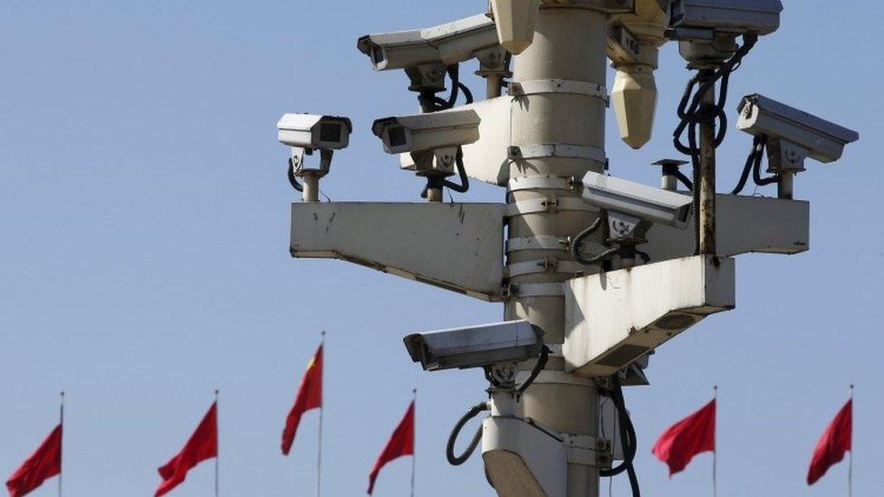 Security cameras in Tiananmen square are seen in front of flags on the Great Hall of the People where the National People's Congress (NPC) is being held (11 March 2016)