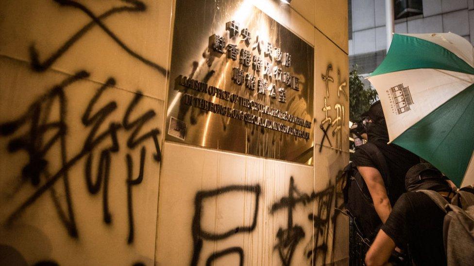 Protesters spray graffiti on the walls of the Chinese government's liaison office in Hong Kong after taking part in an anti-extradition bill march on July 21, 2019