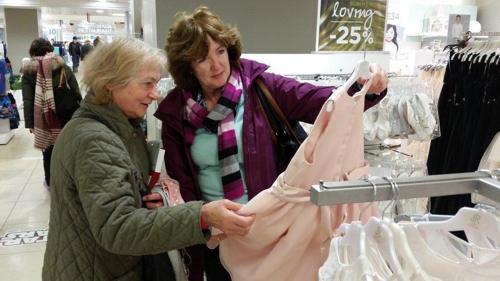 Two women looking at a pink bridesmaids dress