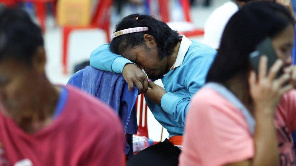 A woman reacts as people gather outside a day care centre which was the scene of a mass shooting