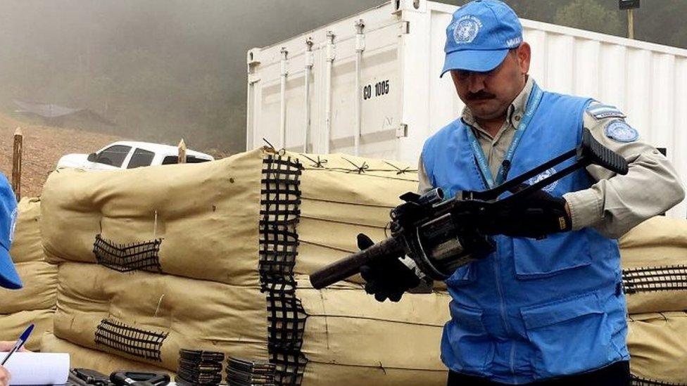 United Nations Mission in Colombia shows one of its members carrying FARC weapons during an inspection at La Elvira, Colombia, 13 June 2017.