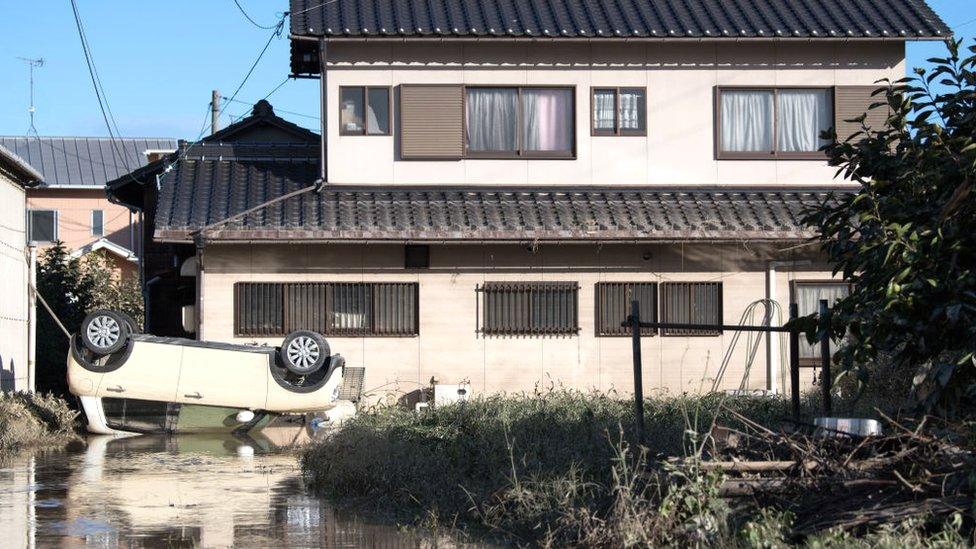 A car lies upside down following heavy flooding, on July 8, 2018 in Kurashiki near Okayama, Japan