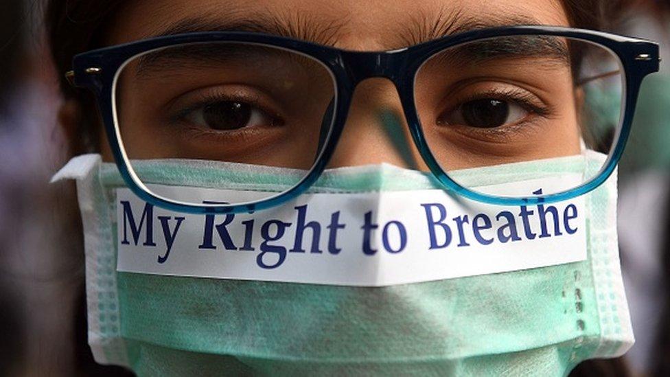 An Indian youth wearing a pollution mask participates in a march to raise awareness of air pollution levels in New Delhi on November 15, 2017.