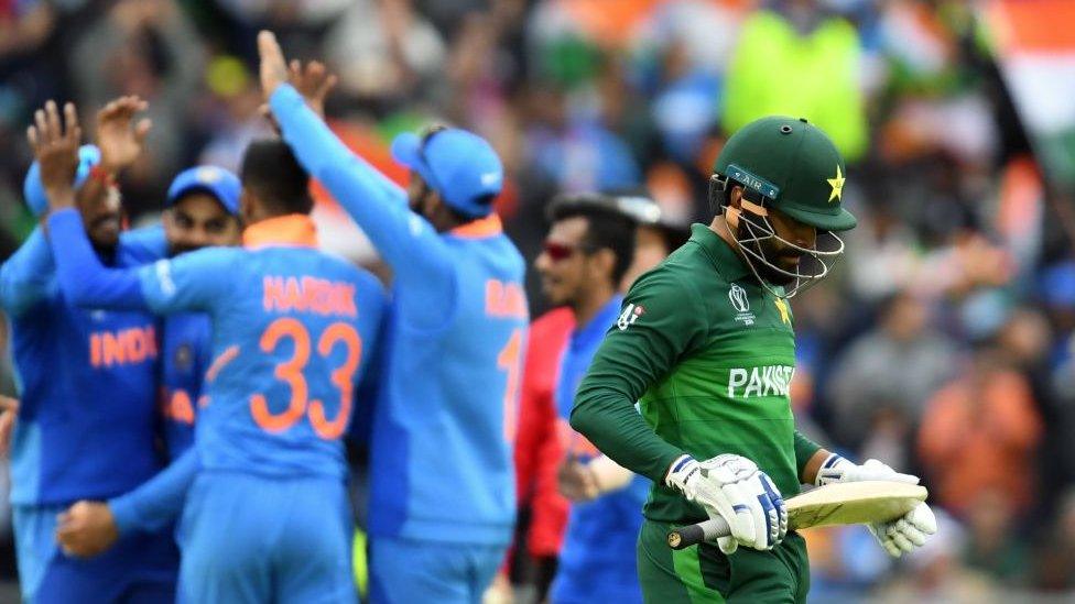 Pakistan's Mohammad Hafeez (R) walks back to the pavilion after his dismissal during the 2019 Cricket World Cup group stage match between India and Pakistan at Old Trafford in Manchester.