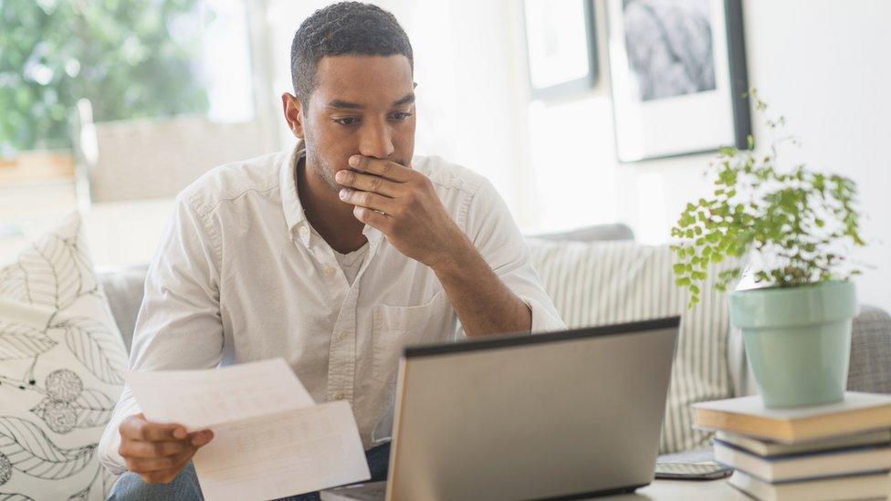 A person looking stressed while looking at bills