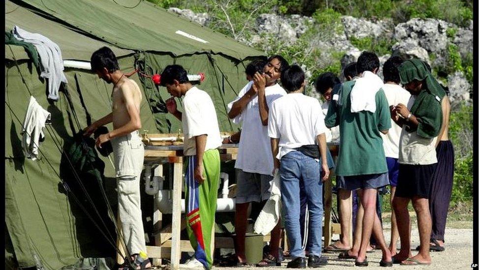 Men shave, brush their teeth and prepare for the day at a refugee camp on the Island of Nauru, Friday, Sept. 21, 2001. Boat loads of asylum seekers have been arriving over three days after more than 500 people were refused entry into Australia.