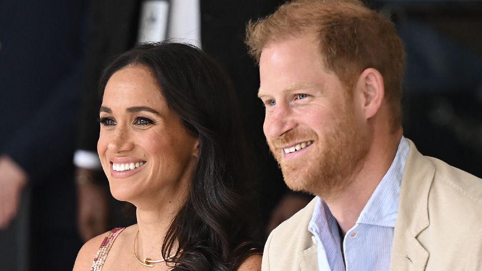 Close up of Harry and Meghan sat next to each other smiling.