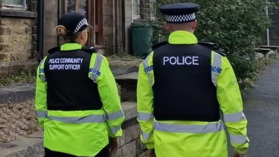 Two police officers walking down the street