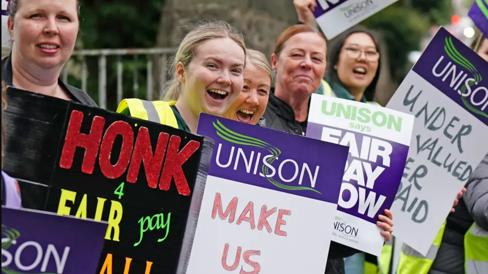 A group of women holding placards on a picket line