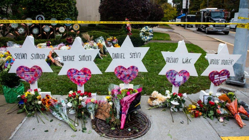 Flowers and stones are placed on the memorials erected outside of the Tree of Life Synagogue in Squirrel Hill