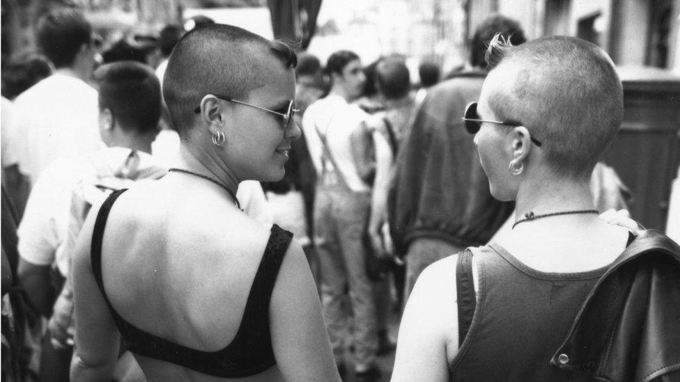 A lesbian couple hold hands during the annual Gay Pride march through central London, July 1993.