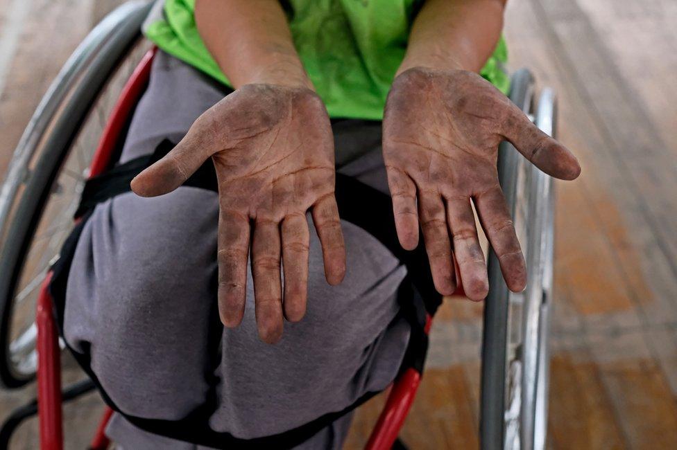 A player shows her hands, dirty from handling the ball