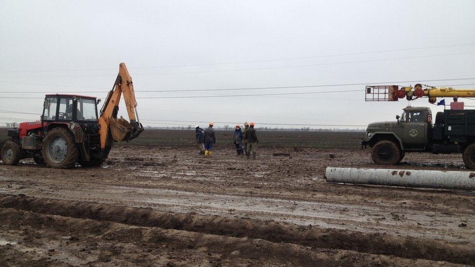 Workers try to repair the broken pylons at Chaplynka