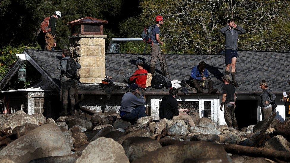 Rescuers on roof of house buried by mudslide in California. 10 Jan 2018