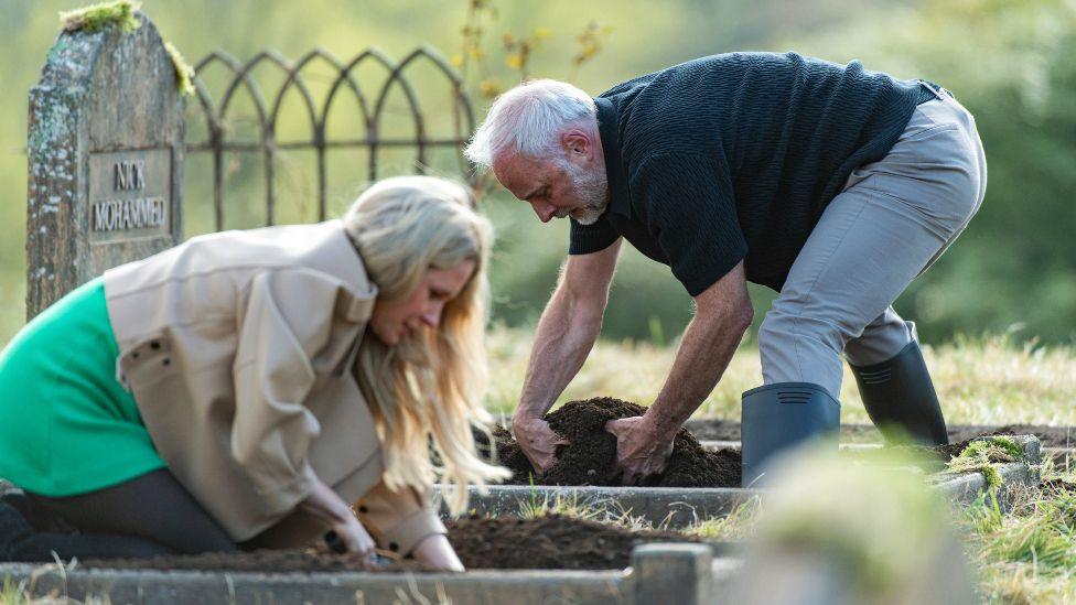 Lucy Beaumont and Mark Bonnar digging through soil, looking for shields