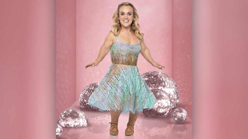 ellie simmonds wearing a sparkly dress posing in front of lots of glitterballs