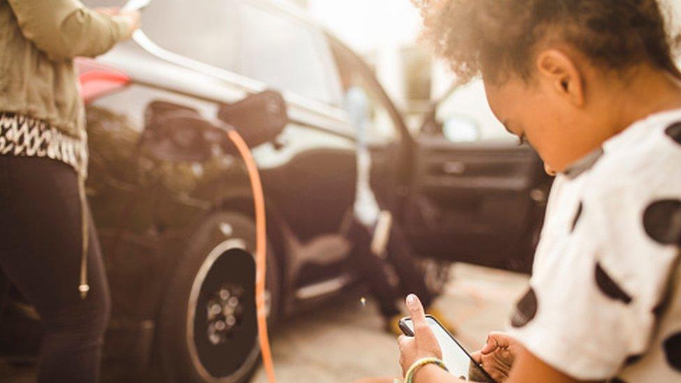 charging car child waiting on phone