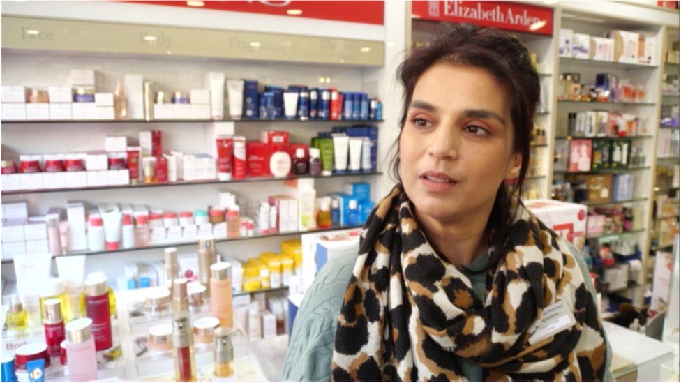 Farah Ali, local pharmacist, standing at the till