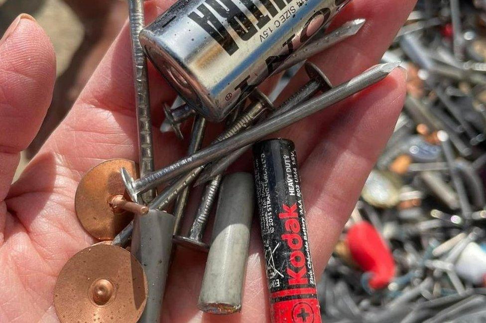 Nails and batteries in a person's hand