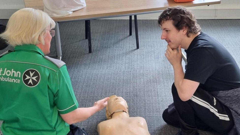 Comedian Tom Mayhew receives training from a St John Ambulance worker