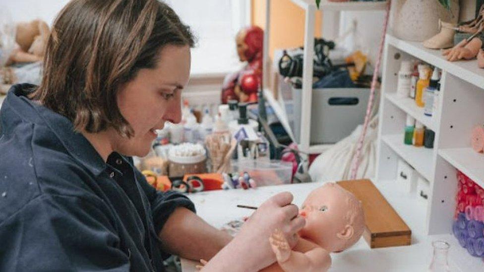 Charlotte Abbot painting a dolls face