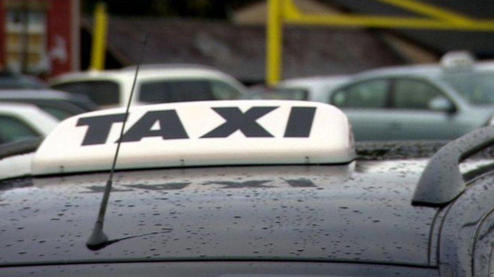 A taxi sign on top of a car