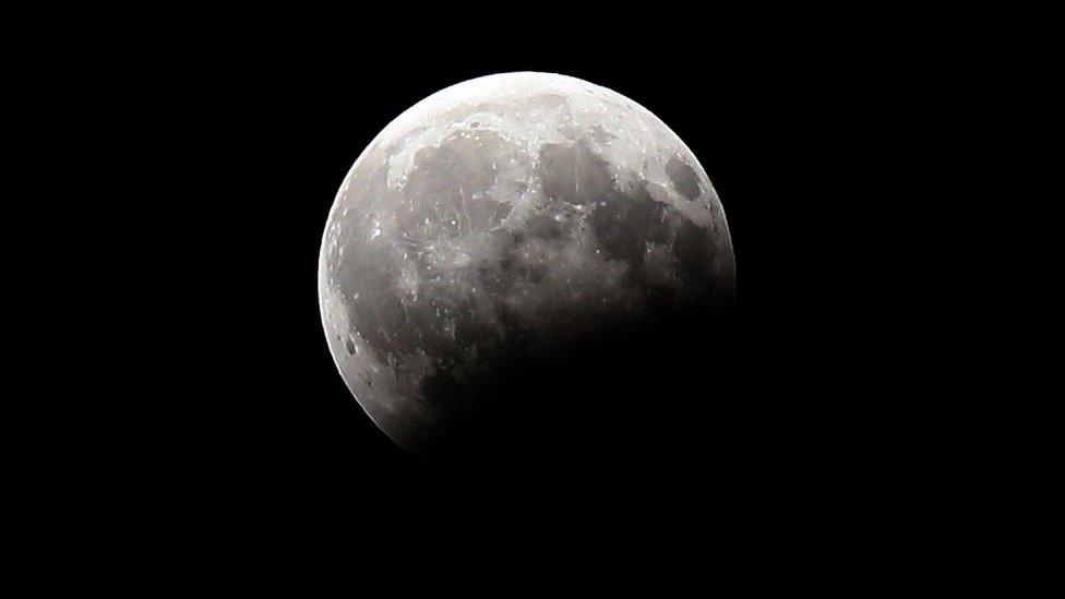 A picture shows the moon during a partial lunar eclipse as seen from Kuwait City on August 7, 2017.