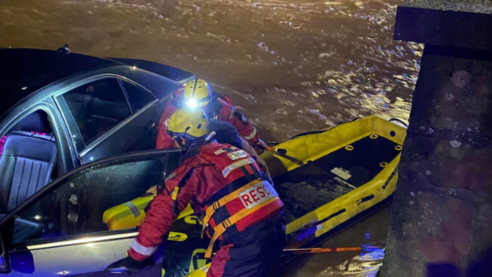 People being rescued from car