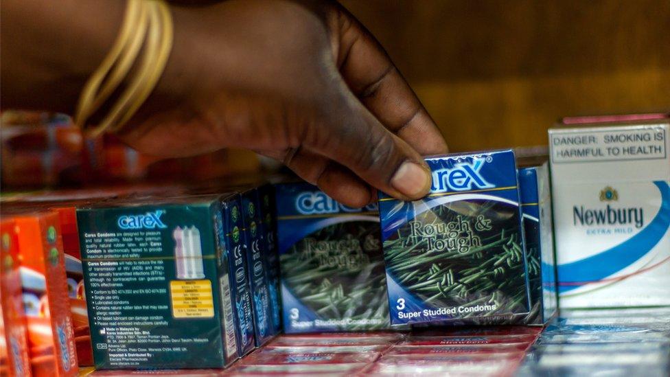 A customer pulls a pack of condoms from a rack in a pharmacy in the Zimbabwean capital Harare (15 May 2015).