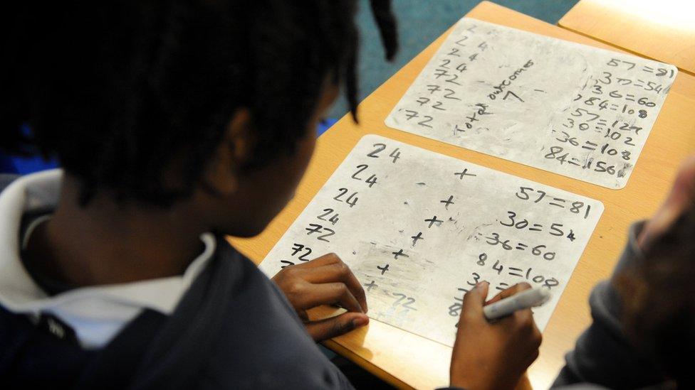 Generic stock image of pupil doing maths work in classroom