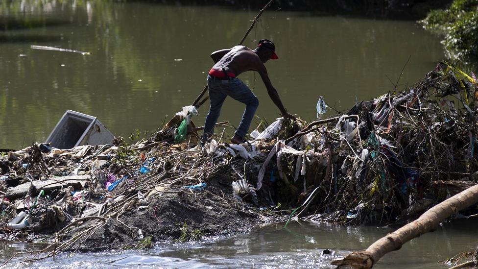 A man crosses a river, in Santo Domingo, Dominican Republic