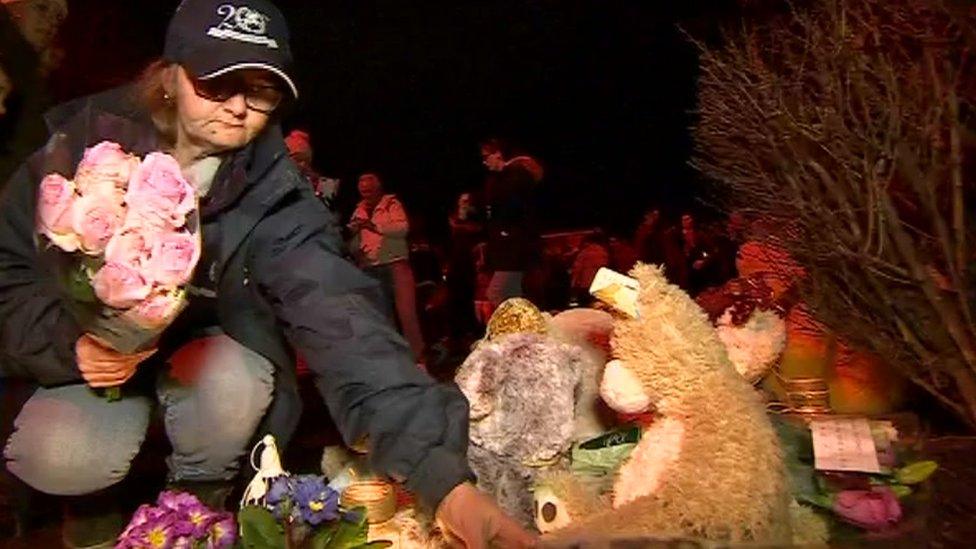 A lady laying flowers near the scene