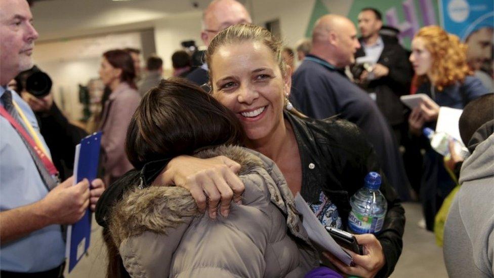 A woman is welcomed home from Sharm el Sheikh at Luton airport