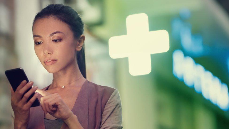 A stock image of a woman looking at her phone