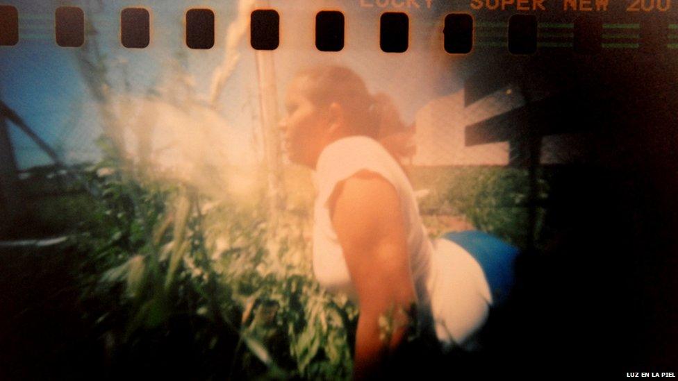 A woman is seen against a fence