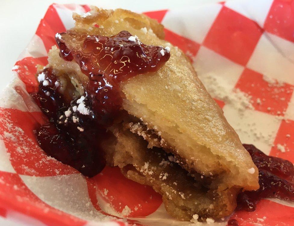 Half a slice of a fried PBJ sandwich, oozing with jam