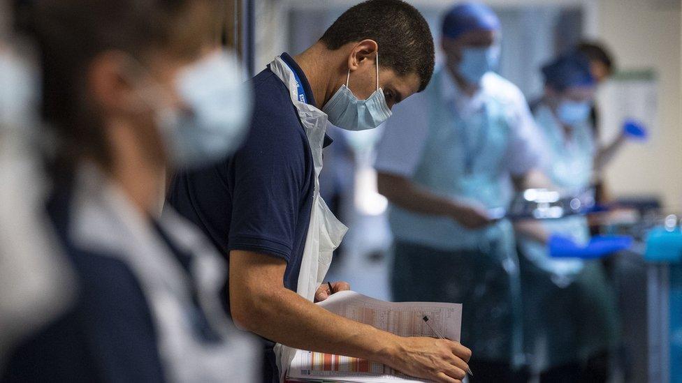 A rehab support worker checks a patient's notes