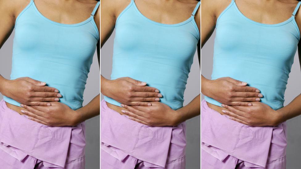 Woman clutching her midriff with period pains