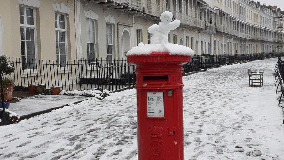 A post box in Royal York Crescent in Clifton, Bristol with a snow man topping