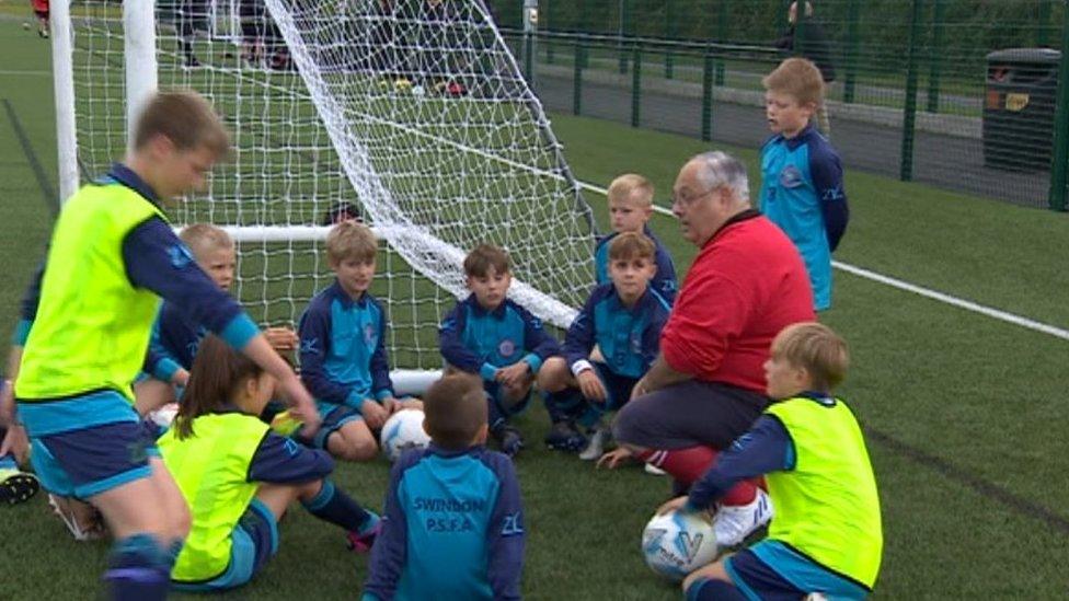 Youngsters listening to their football coach