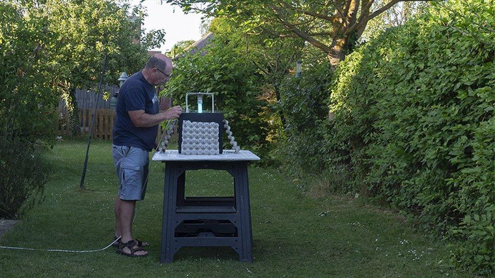 Paul Rule in garden setting up moth trap