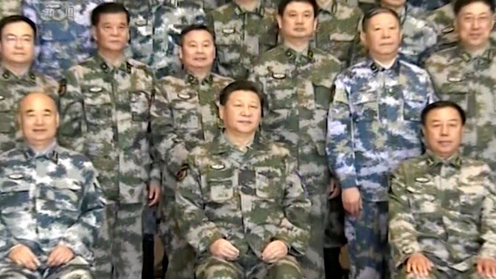 Chinese President Xi Jinping, in military uniform, poses for a group photo with military staff members at the Chinese army's Joint Operation Command Centre in Beijing, 21 April 2016