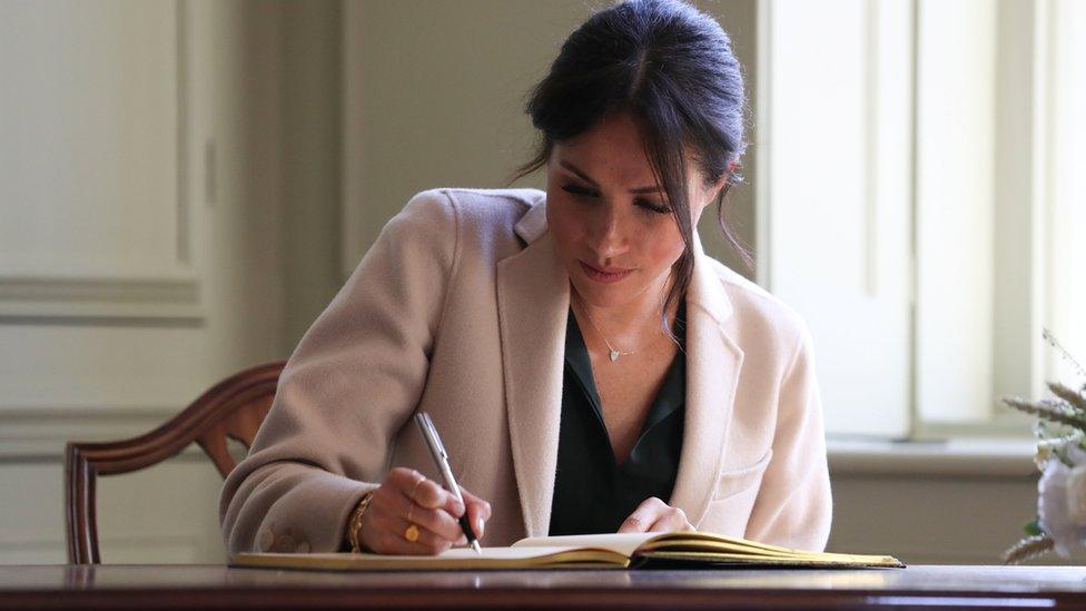 Duchess of Sussex signs the visitor book at Edes House, Chichester