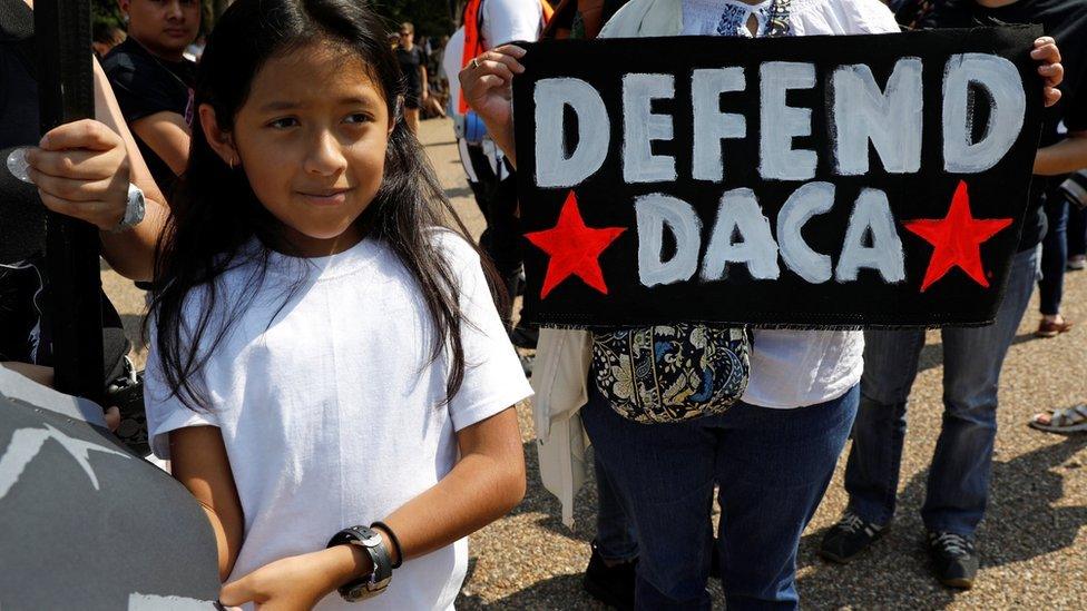 Demonstrators hold signs during a protest in front of the White House, 5 September