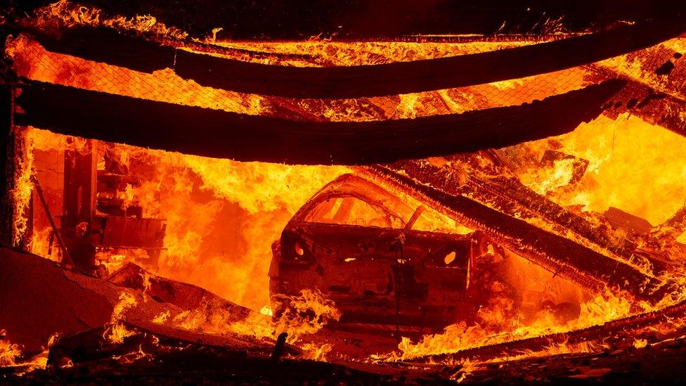 A car burns in a garage as a home goes up in flames during the Hillside fire in the North Park neighbourhood of San Bernardino,