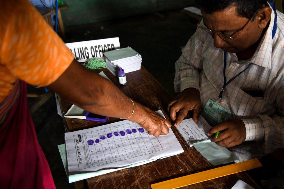 An Indian voter gives her fingerprint as she comes to cast her vote at a polling station during India's general election